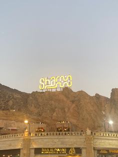 the sign is lit up in front of some mountains