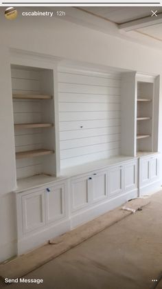 an empty room with built in bookshelves and cabinets