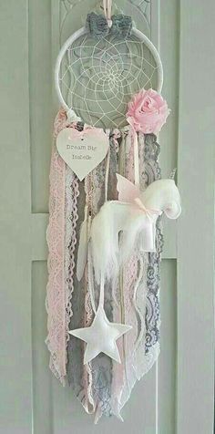 a white dream catcher with pink flowers and stars hanging from it's front door