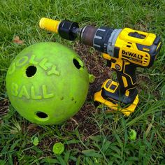 a green ball and two power tools laying on the ground