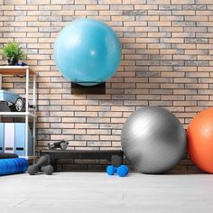 there are several exercise balls on the floor next to each other in front of a brick wall