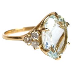 an oval cut aquamarinee and white topazte ring with three diamond accents