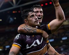 two rugby players are hugging each other in the stadium