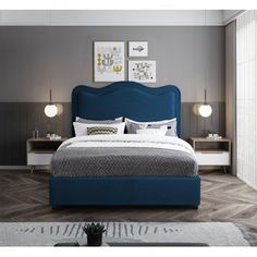 a bed with blue headboard and foot board in a gray room next to a window