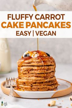 a stack of fluffy carrot cake pancakes with syrup being poured over them on a plate