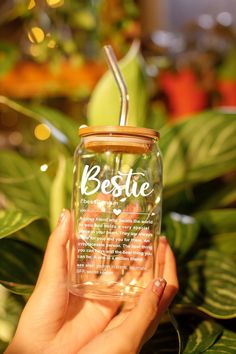 a person holding a glass jar with a straw in it and the words bestie on it