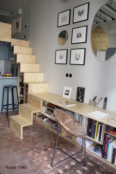 a living room with some bookshelves and pictures on the wall next to it