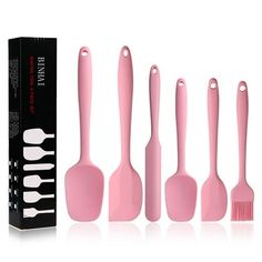 five pink kitchen utensils in front of a box