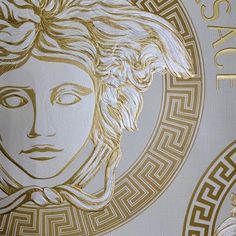 an art deco wallpaper with a woman's face in gold on white background