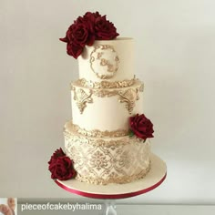 a three tiered wedding cake with red roses on top