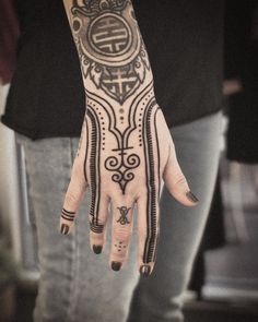 a person's hand with tattoos on it