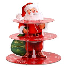 a santa clause holding a christmas ornament on top of three tiered trays