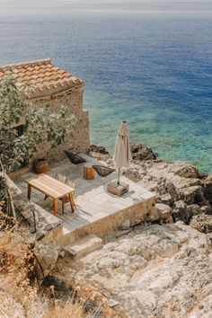 an outdoor seating area on the cliff overlooking the ocean