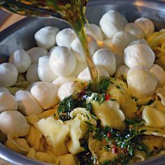 someone is pouring sauce on some food in a bowl