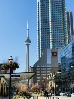 tall buildings stand in the background as people walk by