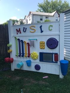 there is a sign that says music with many different things on it in the yard