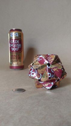 an origami ball next to a can of soda