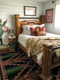 a bedroom with a bed, rugs and pictures on the wall behind it is shown