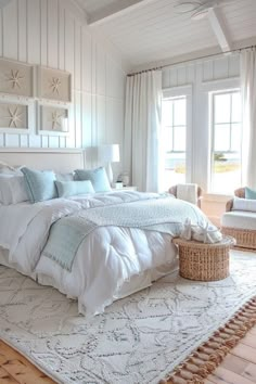 a large white bed sitting in a bedroom on top of a wooden floor next to a window