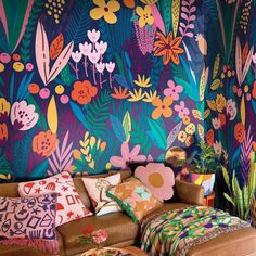 a living room with colorful floral wallpaper and leather couches in front of it