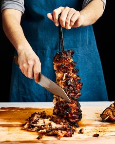 a person cutting meat with a large knife