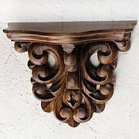 an ornate wooden shelf mounted to the side of a wall