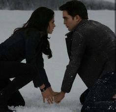 two people are touching hands in the snow