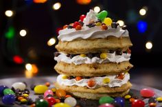 a stack of cookies topped with candy and whipped cream