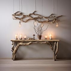 a wooden table topped with candles and branches