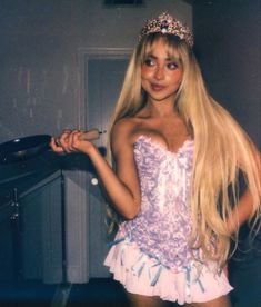 a woman with long blonde hair wearing a purple corset and holding a frying pan