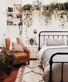 a bed room with a neatly made bed and lots of plants