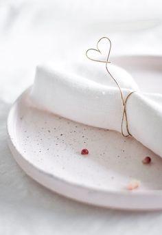 a white plate topped with a heart shaped napkin