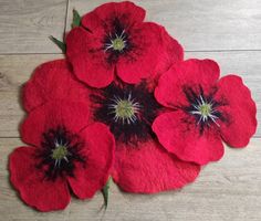 four red flowers are placed on the floor