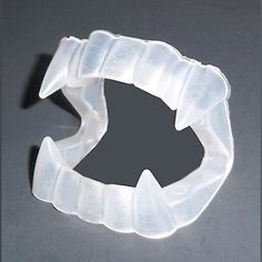 an object made out of plastic sitting on top of a gray surface with a hole in the middle