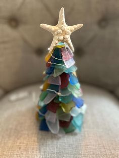 a starfish on top of a stack of colored glass beads in the shape of a christmas tree