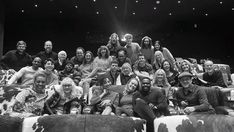 a group of people sitting on top of couches in front of a theater stage