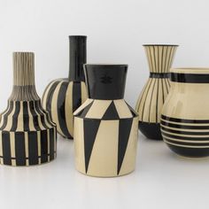 several black and white vases sitting next to each other