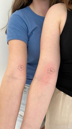 two women with matching tattoos on their arms