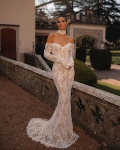 a woman in a wedding dress standing on a balcony