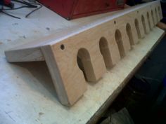 a piece of wood with holes in it on top of a workbench that is being worked on