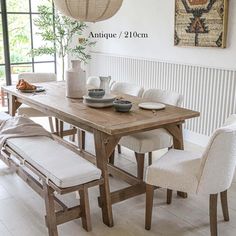 a dining table with four chairs and a bench in front of the table is shown