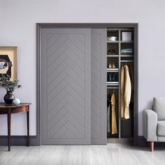 a living room with an open closet and white couch next to the door that has a gray herringbone pattern on it