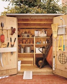 an outdoor storage shed with gardening tools in it