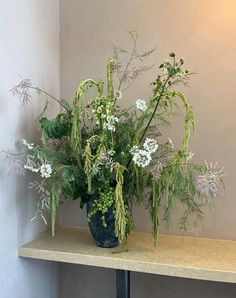 a blue vase filled with lots of green and white flowers