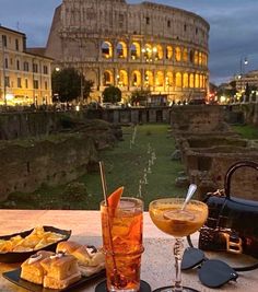 a table with food and drinks on it in front of the colossion