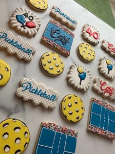 decorated cookies are displayed on a table with the names of tennis players and their name tags