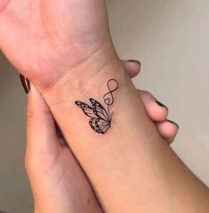 two people holding each other's hands with tattoos on their wrists and one has a butterfly tattoo on the wrist