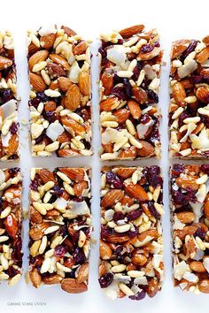 four bars with nuts and cranberry toppings cut into squares on top of each other