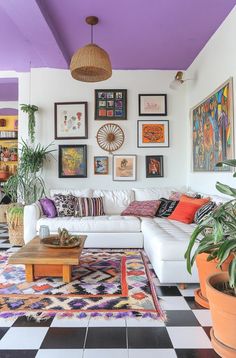 a living room filled with lots of furniture and pictures on the wall above it's coffee table