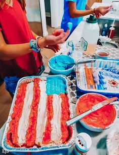 two people are making an american flag cake